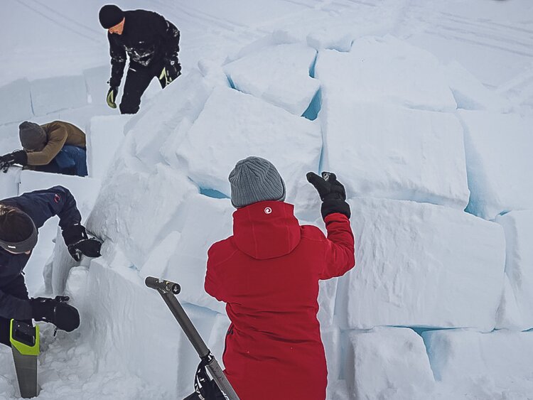 Vier Personen bauen gemeinsam zwei Iglus und übernachten danach in diesen. | © Davos Klosters Mountains
