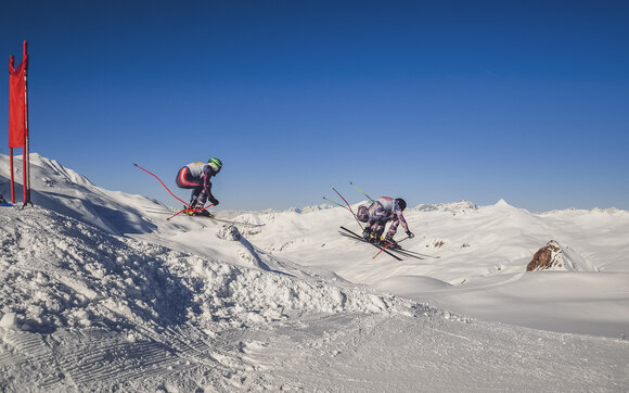 Eine Gruppe Skirennfahrer auf einem Sprung am Parsenn Derby in Davos | © Davos Klosters Mountains