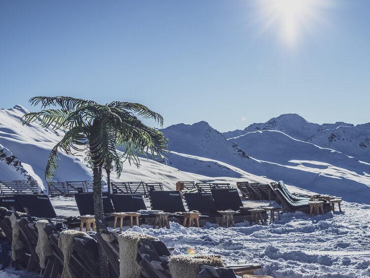Unter Palmen auf der Sonnenterrasse entspannen, zu Sounds von internationalen DJs. | © Davos Klosters Mountains