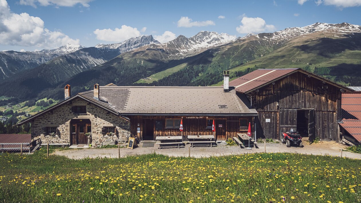 Blick auf die Schaukäserei mit den Bergen von Davos im Hintergund. | © Davos Klosters Mountains