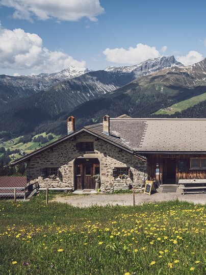 Blick auf die Schaukäserei mit den Bergen von Davos im Hintergund. | © Davos Klosters Mountains