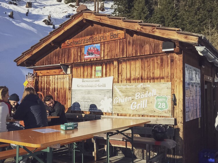 Die kleine rustikale Schwarzseealp Bar gestuhlt mit einfachen Festbänken. | © Davos Klosters Mountains