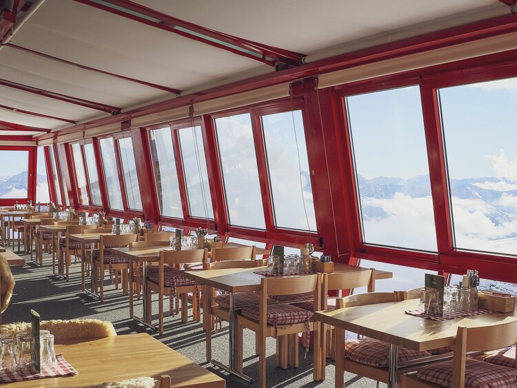 Gedeckte Tische aufgereiht im Bergrestaruant Weissfluhjoch mit Panorama Sicht. | © Davos Klosters Mountains