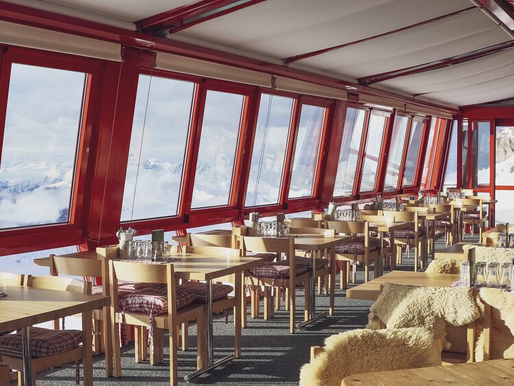 Schlicht eingerichtetes Restaurant am Weissfluhgipfel mit hohen Panoramafenstern welche Sicht auf die Bündner Berge versprechen. | © Davos Klosters Mountains