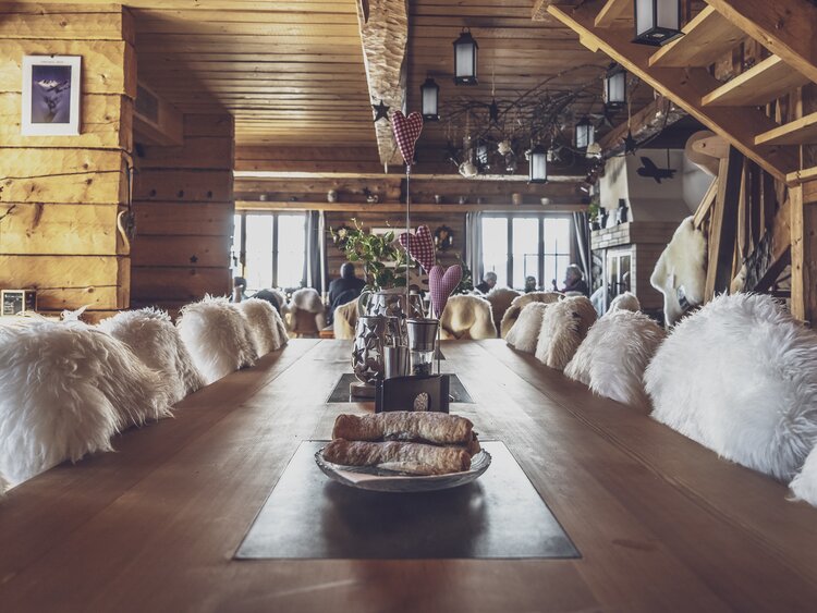Langer Tisch, mit ganz besonderem Charme, steht bereit für die Gäste im Bergrestaurant Mäderbeiz Davos. | © Davos Klosters Mountains