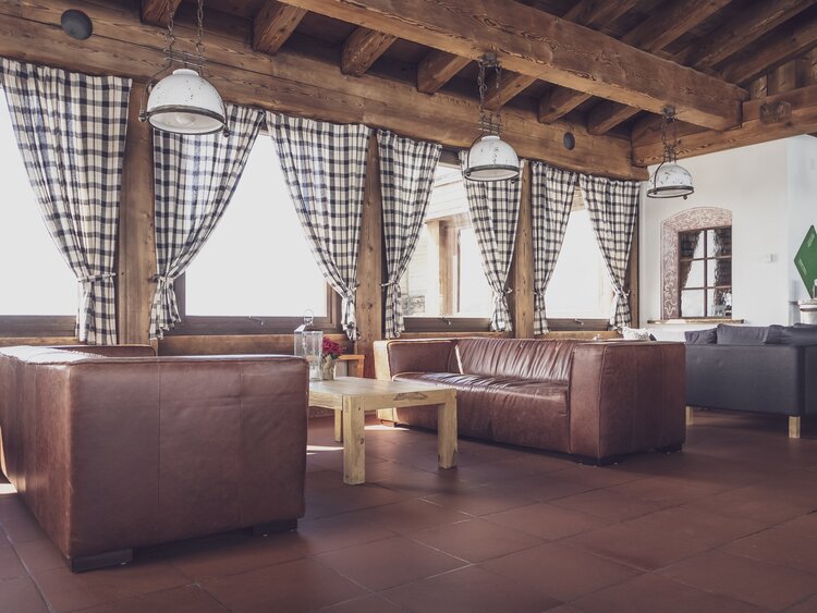 Rustic, brown leather sofas furnished for the lounge in the mountain restaurant Pischa Davos. | © Davos Klosters Mountains