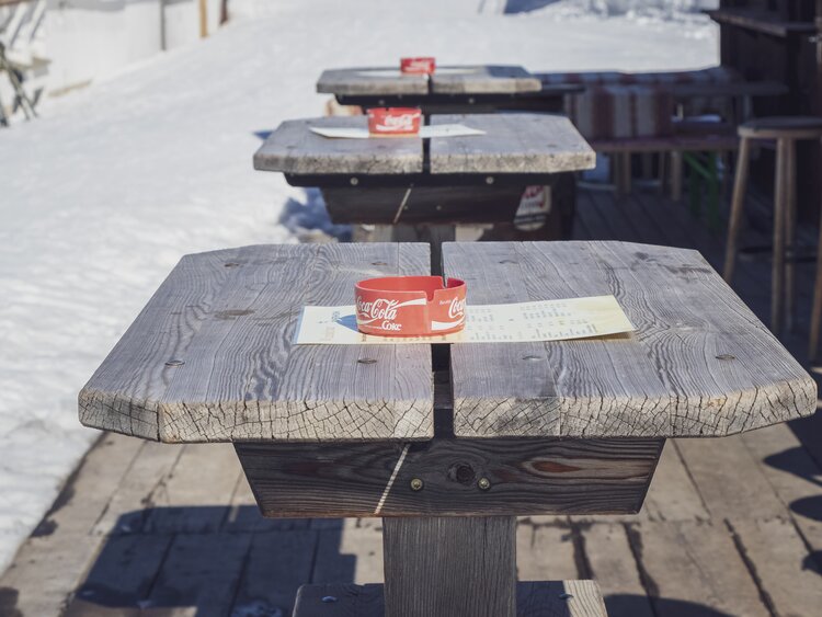Hölzerne Stehtische stehen in der Wunderbar bereit inklusive Aschenbecher. | © Davos Klosters Mountains