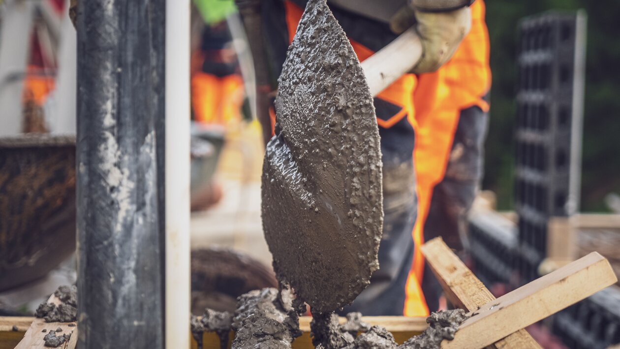 Ein Arbeiter kippt seine Schaufel und leert den Beton an den gewünschten Ort. | © Davos Klosters Mountains