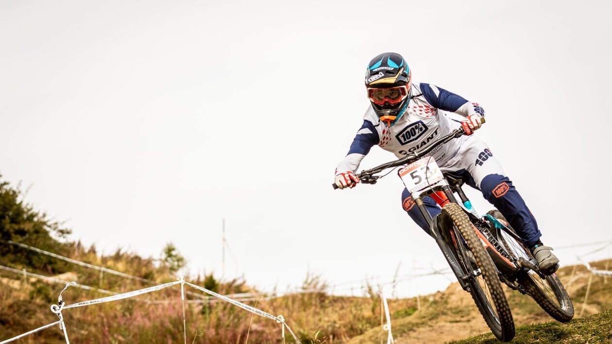 In voller Montur fährt der Downhill  Biker an einem Rennen mit.  | © Matteo Manno