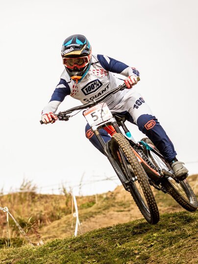 In voller Montur fährt der Downhill  Biker an einem Rennen mit.  | © Matteo Manno