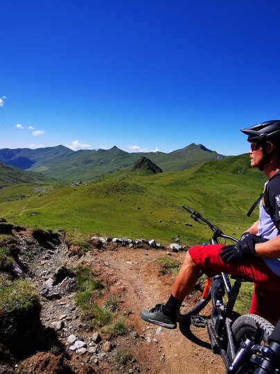 Ein Biker geniesst die Aussicht auf dem Grünsee Trail. | © Christoph Koch