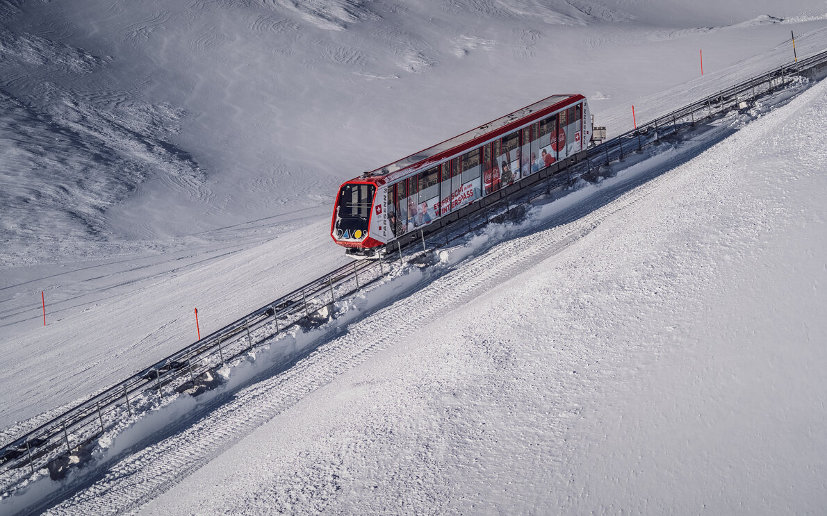 Die rote Standseilbahn Parsenn fährt durch die winterliche Landschaft auf den Berg.  | © Davos Klosters Mountains