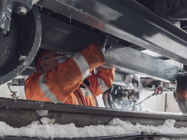 Ein Arbeiter montiert die letzten Schrauben, damit das neue Schneegebläse auf dem Gleis fahren kann.  | © Davos Klosters Mountains