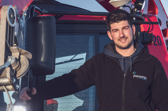 Nino, Pistenbully-Fahrer auf Parsenn, posiert vor seinem riesen Fahrzeug. | © Davos Klosters Mountains