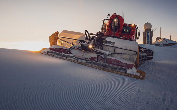Der Pistenbully präpariert die Piste auf dem Weissfluhgipfel bei wunderschöner Abendstimmung.  | © Davos Klosters Mountains