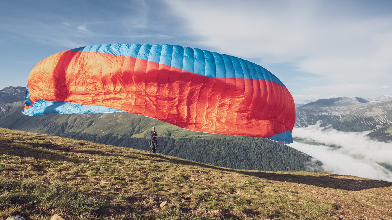 Der Pilot zieht den imposanten Gleitschirm in die Luft. | © Davos Klosters Mountains
