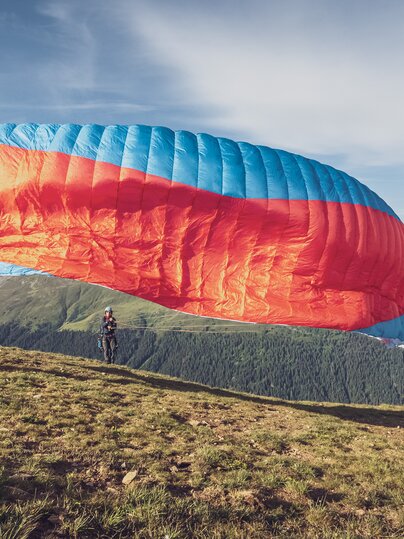 Der Pilot zieht den imposanten Gleitschirm in die Luft. | © Davos Klosters Mountains