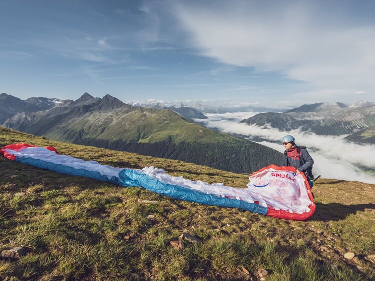 Der Pilot breitet den Gleitschirm beim Startplatz Jakobshorn aus und bereitet so den Abflug vor. | © Davos Klosters Mountains