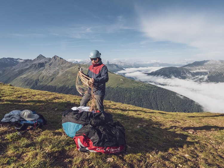 Der Pilot packt beim Startplatz Jakobshorn den Gleitschirm aus und bereitet alles für den Flug vor. | © Davos Klosters Mountains