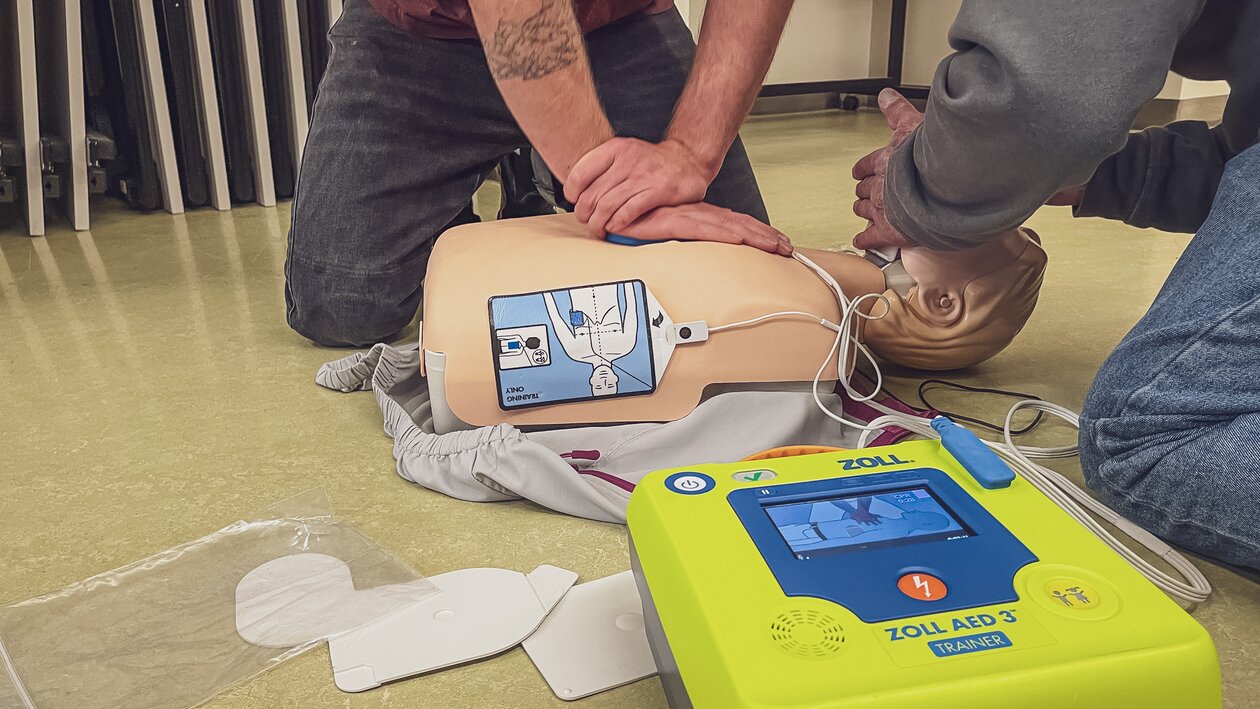 Männliche Person führt Herzdruckmassage an Dummy aus.  | © Davos Klosters Mountains 