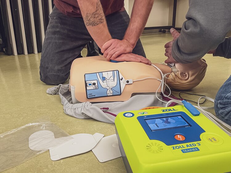 Männliche Person führt Herzdruckmassage an Dummy aus.  | © Davos Klosters Mountains 
