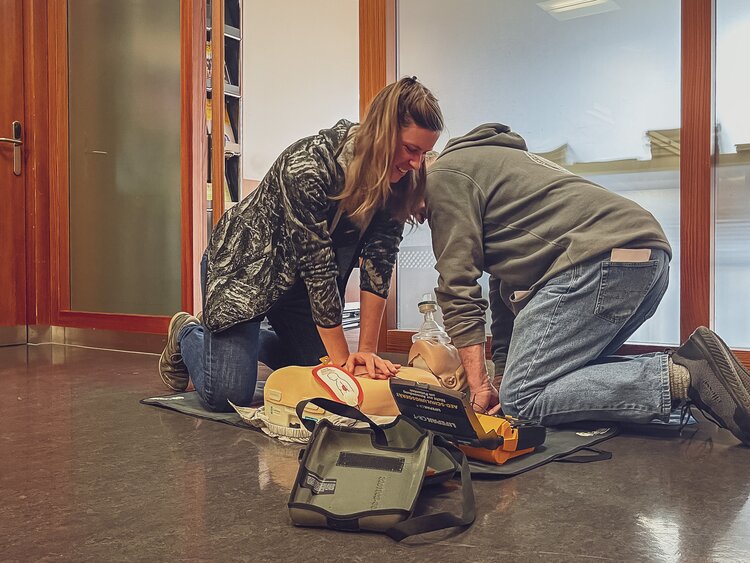 2 Personen führen Herzdruckmassage an Dummy aus | © Davos Klosters Mountains 
