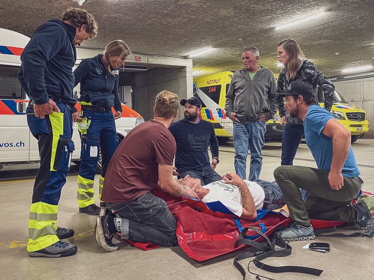  Gruppe Personen übt an einem lebenden Statisten den Abtransport unter Aufsicht der Sanitäter  | © Davos Klosters Mountains 