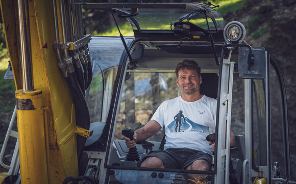 Portrait des langjährigen Mitarbeiters Andreas Grassel auf seinem Arbeitsgerät dem Menzi Muck Bagger. | © Davos Klosters Mountains