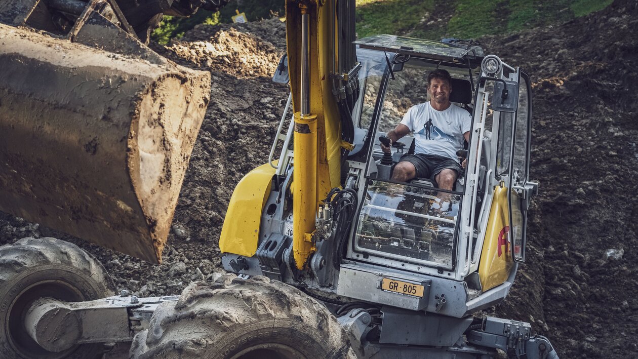 Andreas Grassel arbeitet mit dem gelben Menzi Muck Bagger. | © Davos Klosters Mountains