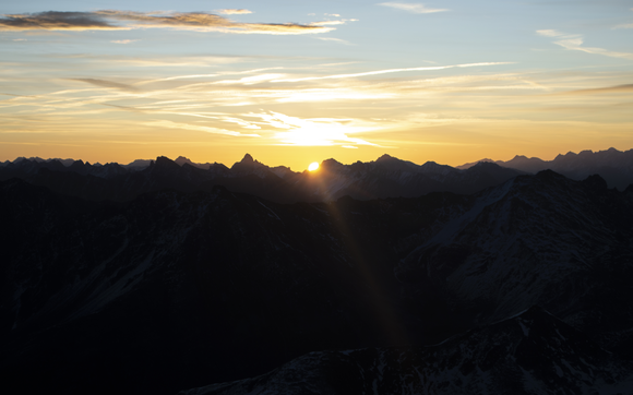 Blick vom Schwarzhorn auf den Sonnenaufgang hinter der Hügelkette. | © Davos Klosters Mountains