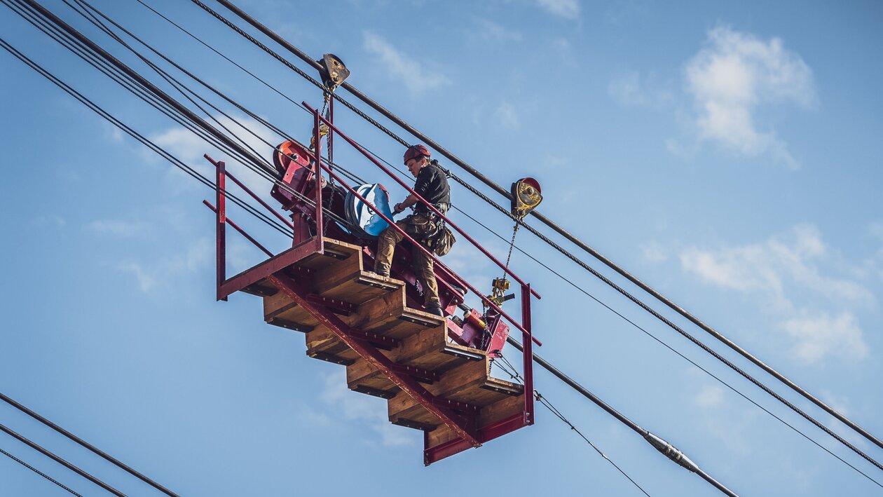 Der Arbeiter steht auf der sogenannten Meklmaschine mit welcher das Seil schrittweise auf den Berg gezogen wird. | © Davos Klosters Mountains