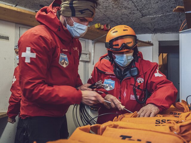 Die beiden Patrouilleure bringen die Zündschnur- und kapsel am Sprengstoff an. | © Davos Klosters Mountains