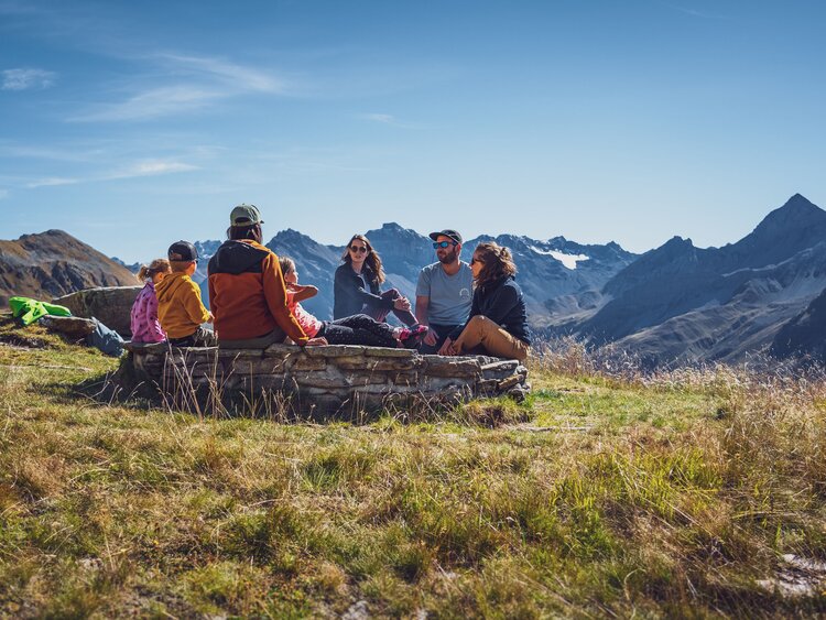 Eine Familie sitzt an einer Grillstelle auf dem Jakobshorn und geniesst das Bergpanorama. | © Davos Klosters Mountains