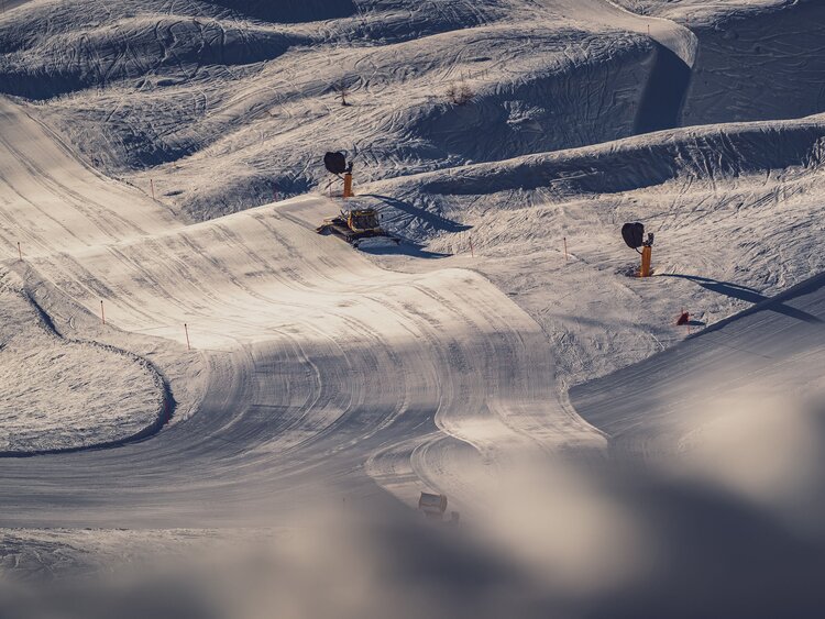 Im goldenen Abendlicht fährt der Pistenbully über die Piste und hinterlässt eine perfekt präparierte Spur. | © Davos Klosters Mountains