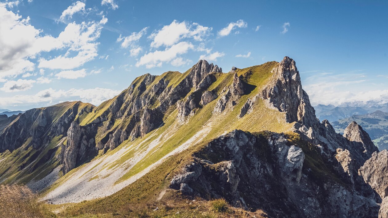 Ein Pfad schlängelt sich über den grünen Hang der Casanna, ein traumhafter Blick vom Gipfel des Grüenhorns.  | © Davos Klosters Mountains