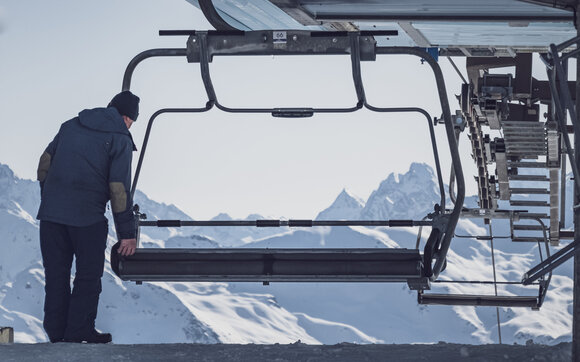 Mitarbeiter auf Parsenn klappt beim Meierhoftäli am anfang des Skitages die Sitze des Sesselliftes hoch. | © Davos Klosters Mountains
