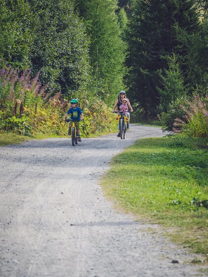 Eine Mutter macht einen Ausflug auf dem Mountainbike mit ihren beiden Kindern. | © Davos Klosters Mountains