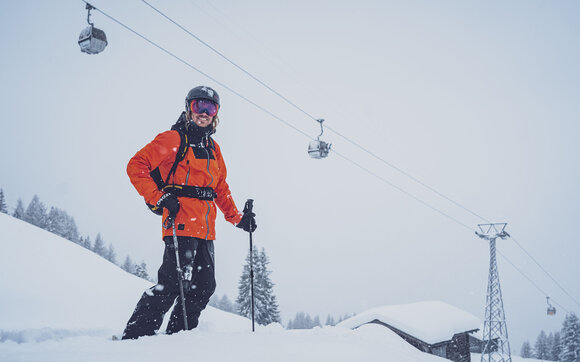 Glücklich steht der Skifahrer im Schnee, hinter ihm die Gondeln des Rinerhorns. | © Davos Klosters Mountains