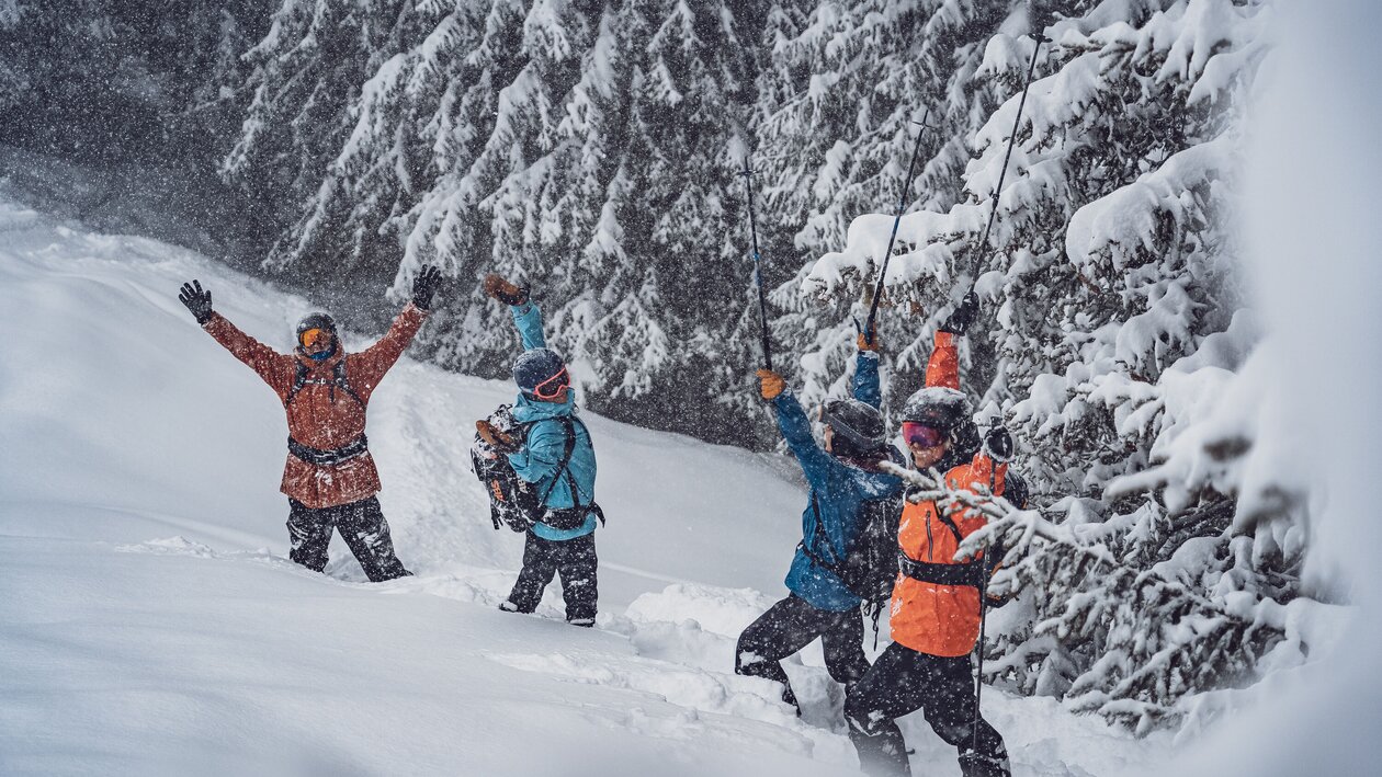 EIne Gruppe Freerider stehen im Tiefschnee auf dem Rinerhorn und feiern, dass es schneit.  | © Davos Klosters Mountains