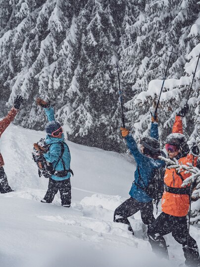 EIne Gruppe Freerider stehen im Tiefschnee auf dem Rinerhorn und feiern, dass es schneit.  | © Davos Klosters Mountains