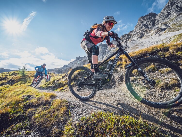 Eine Bikerin geniesst die rasante Abfahrt, ein Biker fährt hinterher. | © Davos Klosters Mountains