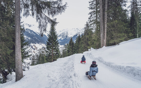 Zwei Freundinnen schlitteln auf der Schlittelstrecke Gotschna ins Tal nach Klosters. | © Davos Klosters Mountains