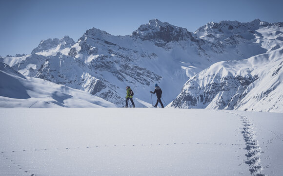 Seitlicher Blick auf zwei Schneeschuhläufer die auf dem Jakobshorn über den unberührten Schnee gehen. | © Davos Klosters Mountains