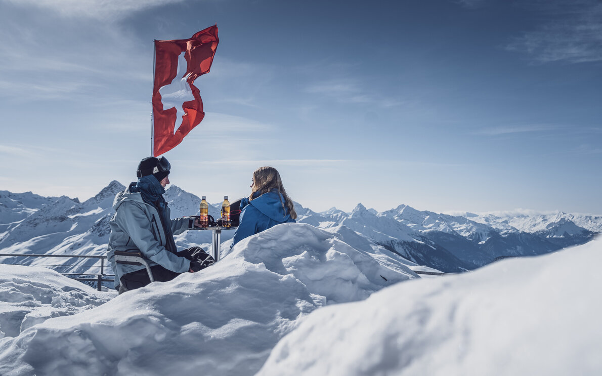 2 Wintersportler beim Rasten auf einer Terasse  | © Davos Klosters Mountains 