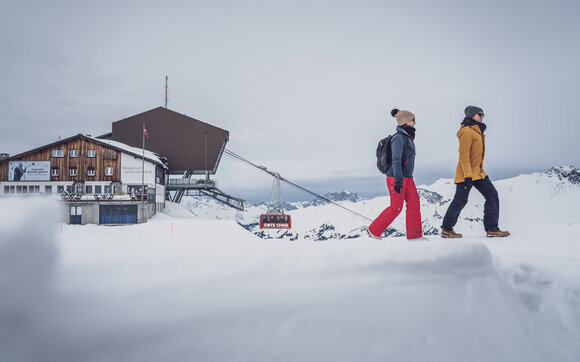 Zwei Freundinnen starten bei der Bergstation eine Winterwanderung auf Parsenn Gotschna. | © Davos Klosters Mountains
