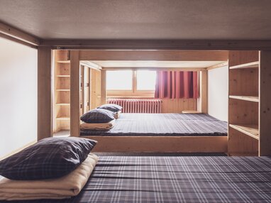 Mehrbettzimmer mit Doppelstockbetten und Kleiderablagen  | © Davos Klosters Mountains 