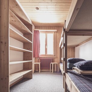 Mehrbettzimmer mit Stockbetten und Kleiderablagen  | © Davos Klosters Mountains 