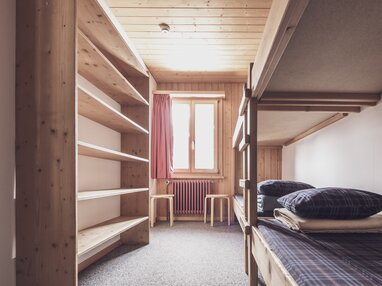 Mehrbettzimmer mit Stockbetten und Kleiderablagen  | © Davos Klosters Mountains 