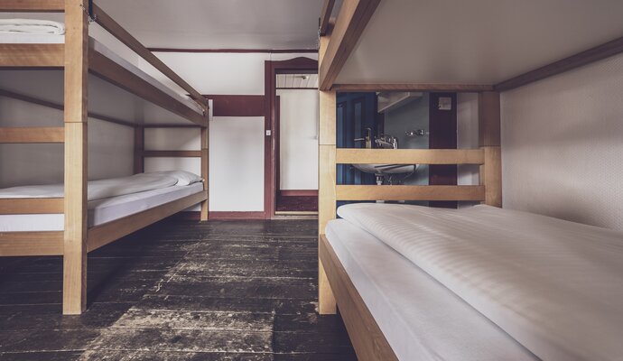 Multi-bed room with bunk beds and washbasin  | © Davos Klosters Mountains 