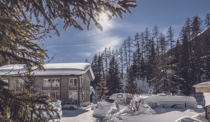 Verschneites Hostel mit Sonne und blauem Himmel | © Davos Klosters Mountains